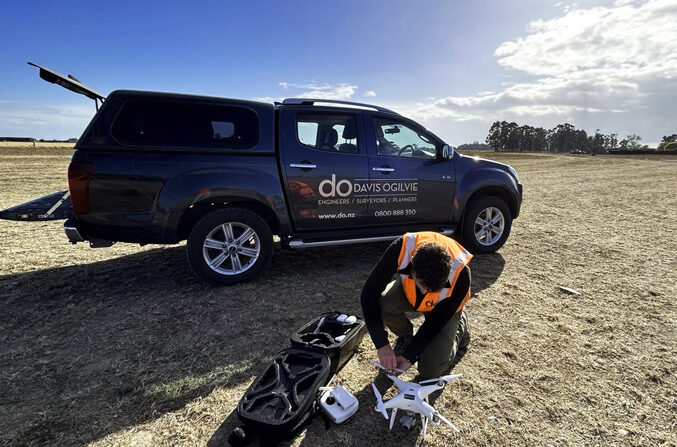 Man crouching down next to drone equipment
