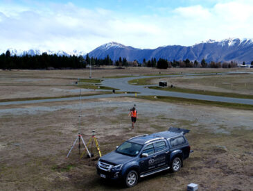 View of residential development with mountains in the background and man with truck in the foreground.