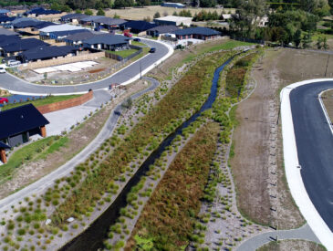 Aerial view of a stream next to a residential development