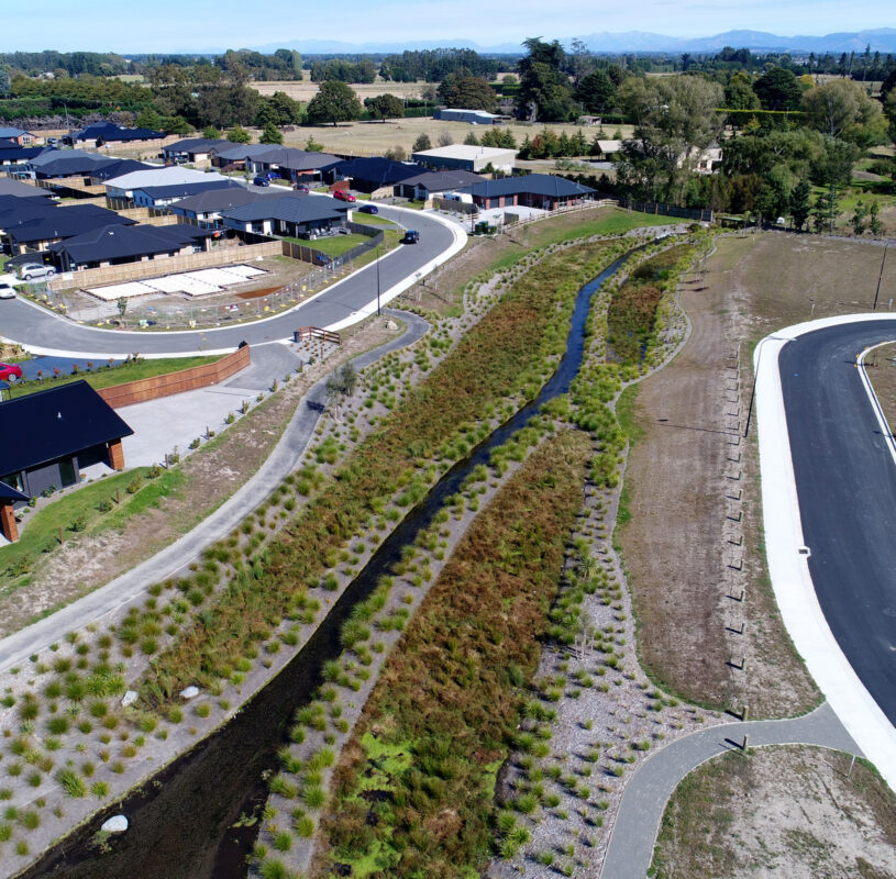 Aerial view of a stream next to a residential development