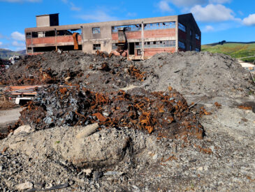 View of a dipalidated building on wasteland on a sunny blue sky day