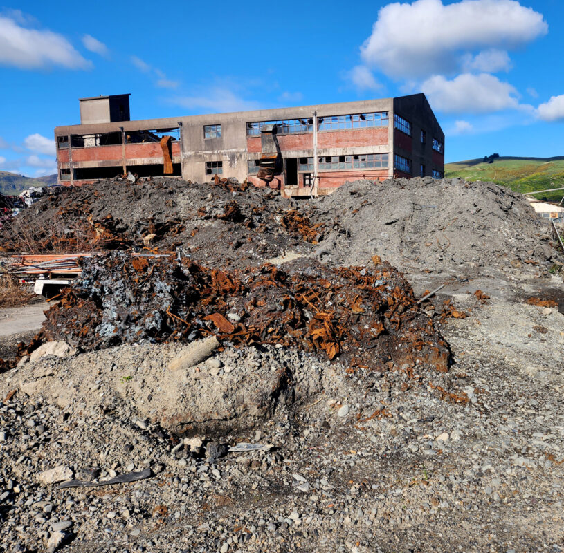 View of a dipalidated building on wasteland on a sunny blue sky day