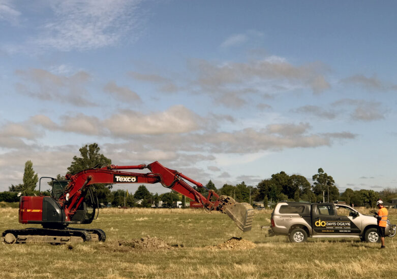 Digger and truck in a field on a sunny day