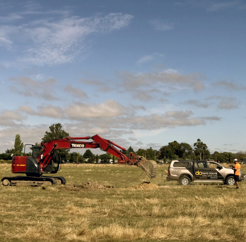 Digger and truck in a field on a sunny day