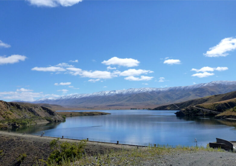 View of water with mountains in the background on a sunny day