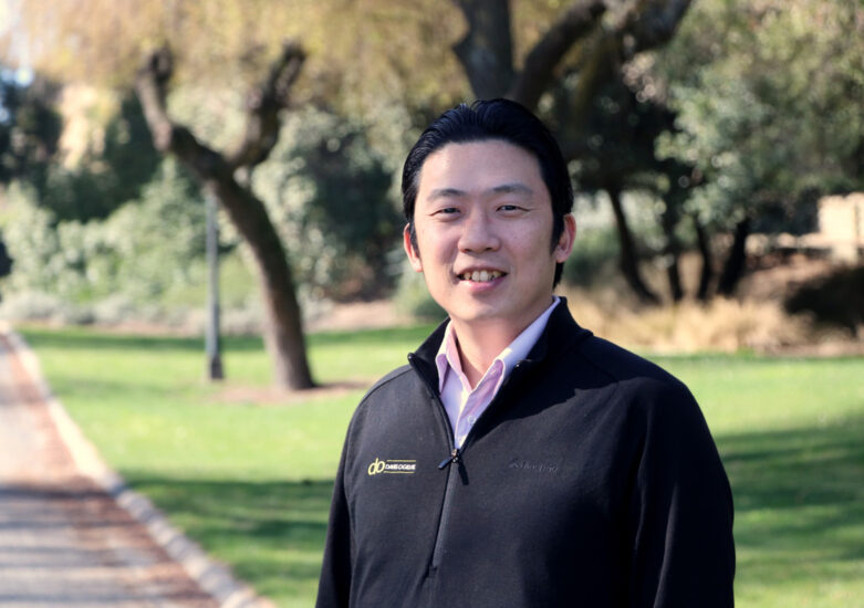 Davis Ogilvie man with dark zip branded top with a park in the background in Timaru.